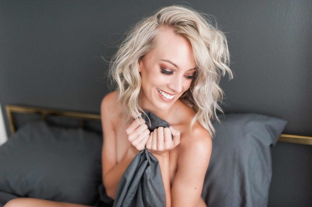 Woman with curly hair holding sheets