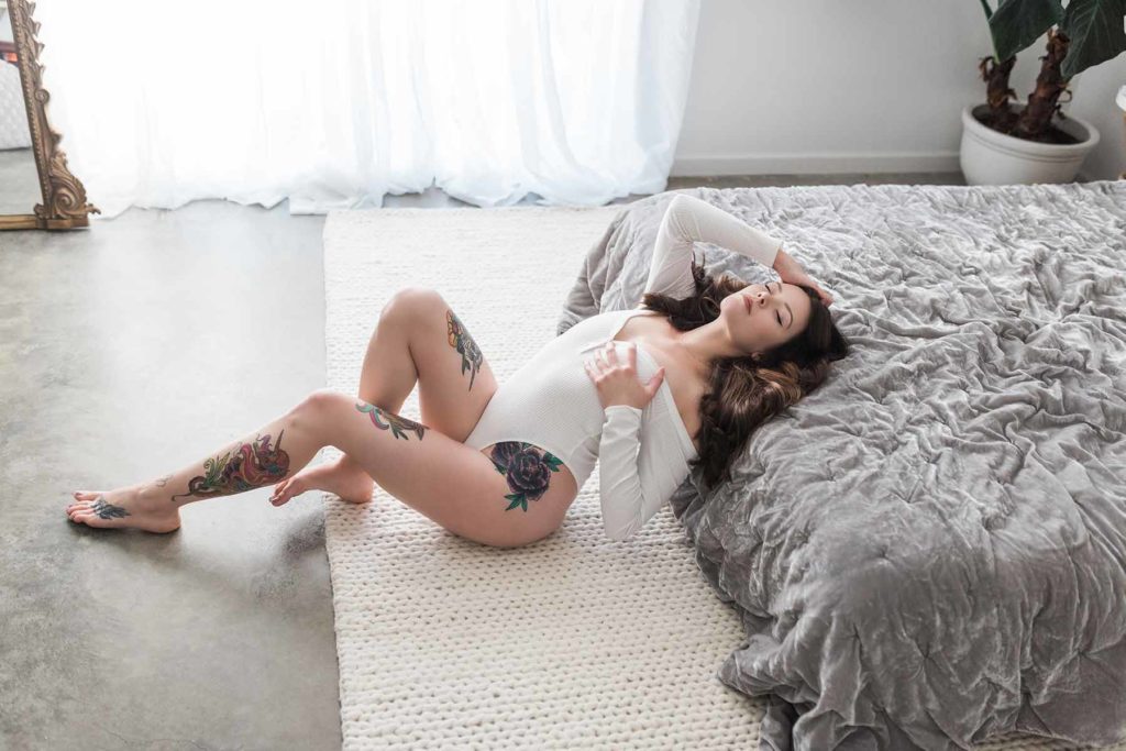 Woman wearing white bodysuit boudoir photoshoot