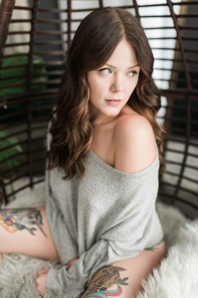 Brunette Woman Seated In Oversized Sweater Boudoir Portrait